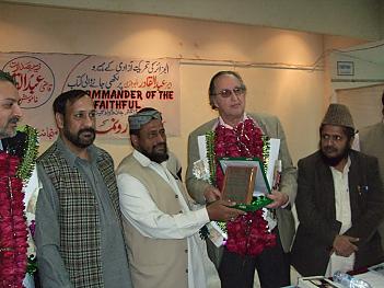 Author receiving plaque celebrating his book from Madrass leader Professor Afridi